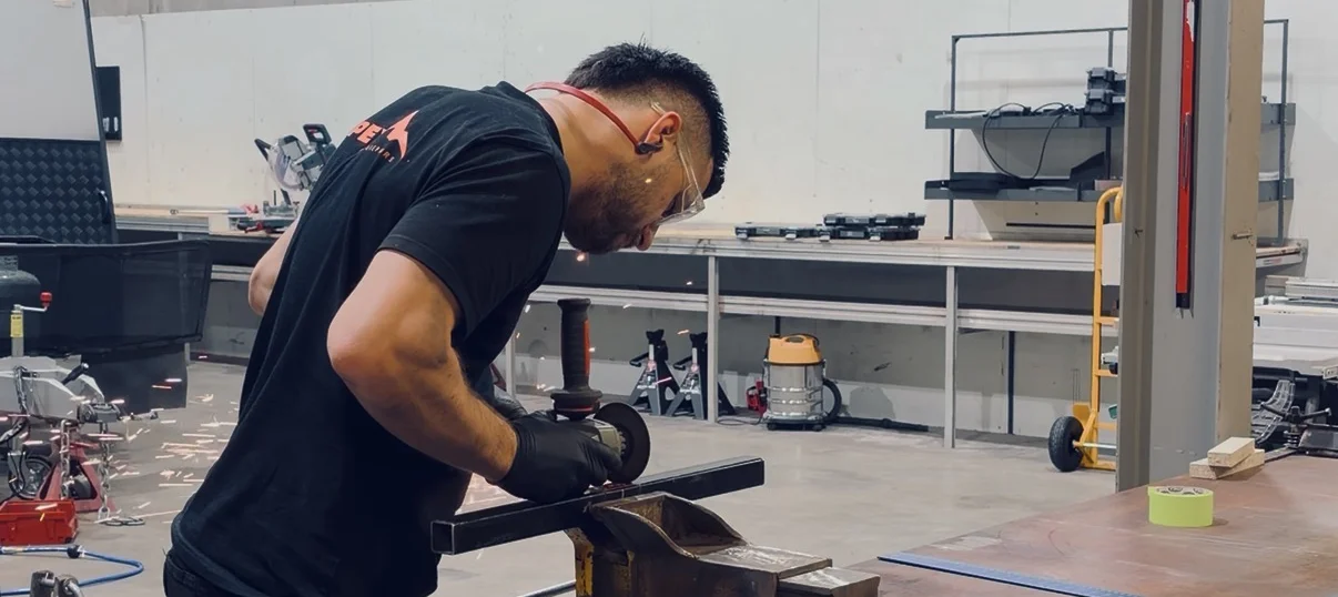Mark grinding and fabricating custom metalwork at Apex workshop