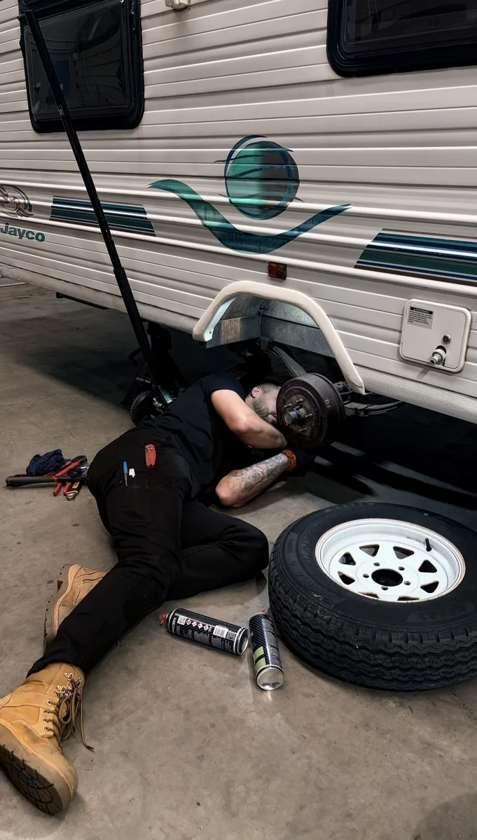 Mark working underneath a Jayco caravan at Apex workshop